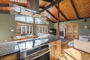 A spacious kitchen with a large island, a dining area, and a living room with a fireplace. - Gunstock Chalet - Close to Gunstock, BNH Pavilion Concerts, and Lake Winni (Gilford)