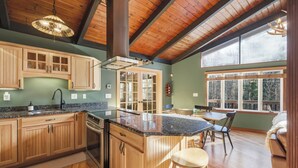 A spacious kitchen with wooden cabinets, a granite countertop, and a large island.