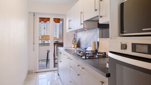 A modern kitchen with a gas stove, oven, and a Samsung refrigerator. - Juan-les-Pins Vitoria Grand 2P – Quiet, Parking, Central Location (Antibes)
