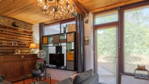 A cozy living room with a fireplace, wooden shelves, a sofa, and a television.
