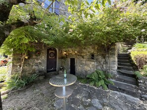 A stone archway leading to a door, a dartboard, and a table with a bottle. - Holiday Home "Mas de Jallet" with Hill Views, Private Pool and Wi-Fi (Les Assions)
