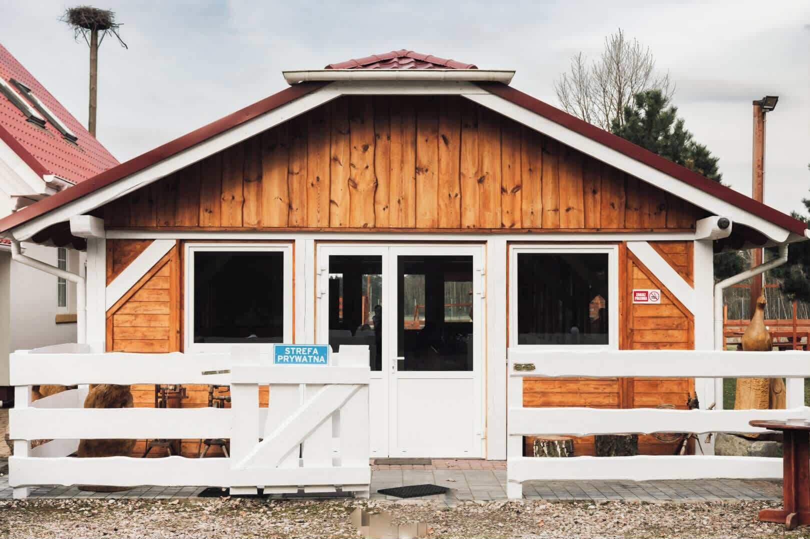 Un bâtiment en bois avec un toit en pente, deux fenêtres visibles et une enseigne indiquant « ZONE PRIVÉE ».