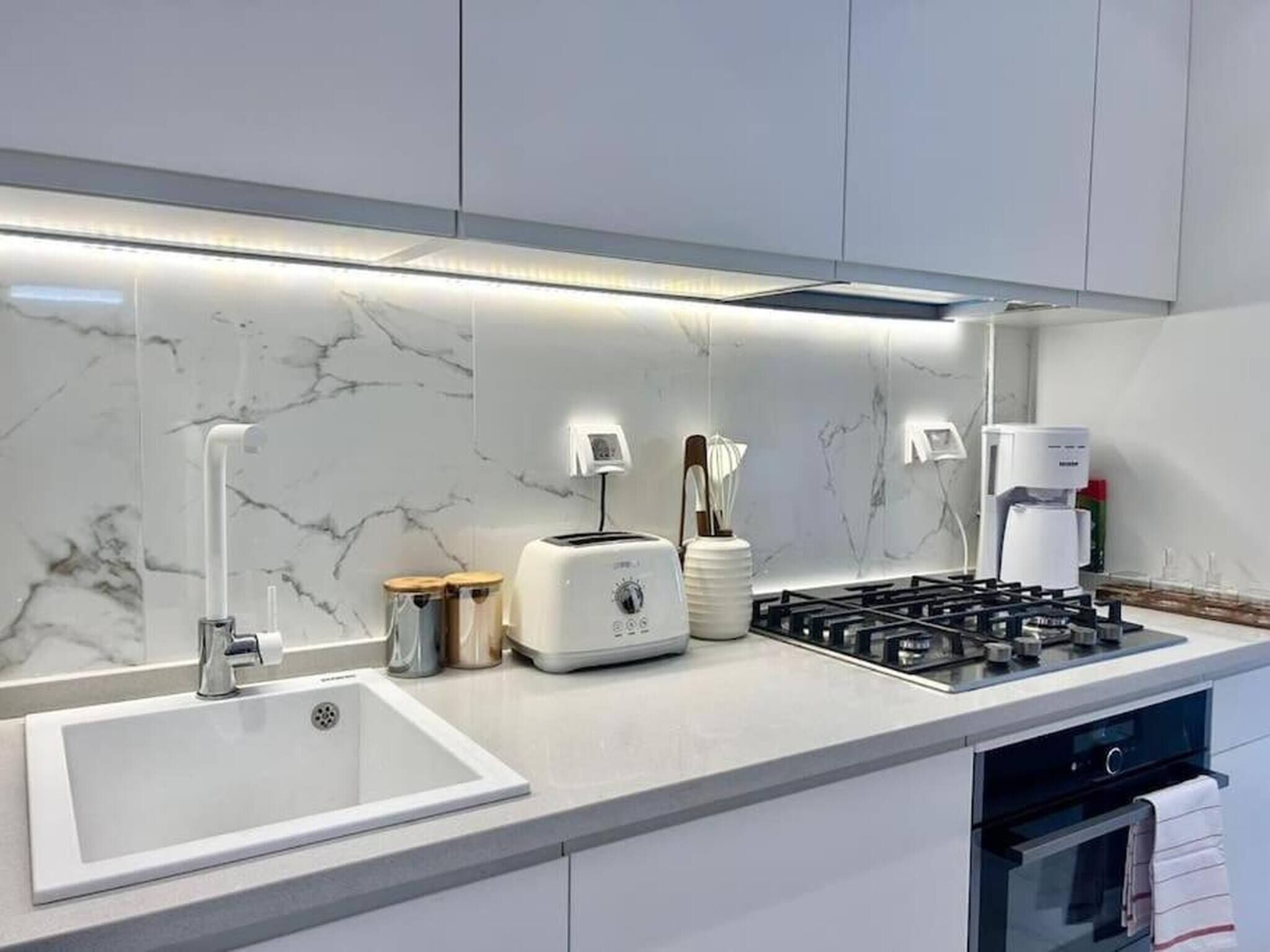 Una cocina moderna con estufa a gas integrada, cafetera y tostadora.