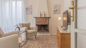 Un salon avec une cheminée, un canapé, une table basse et un meuble en bois.