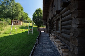 A log cabin with a gravel pathway leading to a swing set and a small shed. - Chalet Serenity - Sleeps 9 - Hot Tub (Liézey)
