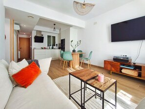 Ein modernes Wohnzimmer mit einer Couch, einem Couchtisch und einem Fernseher.