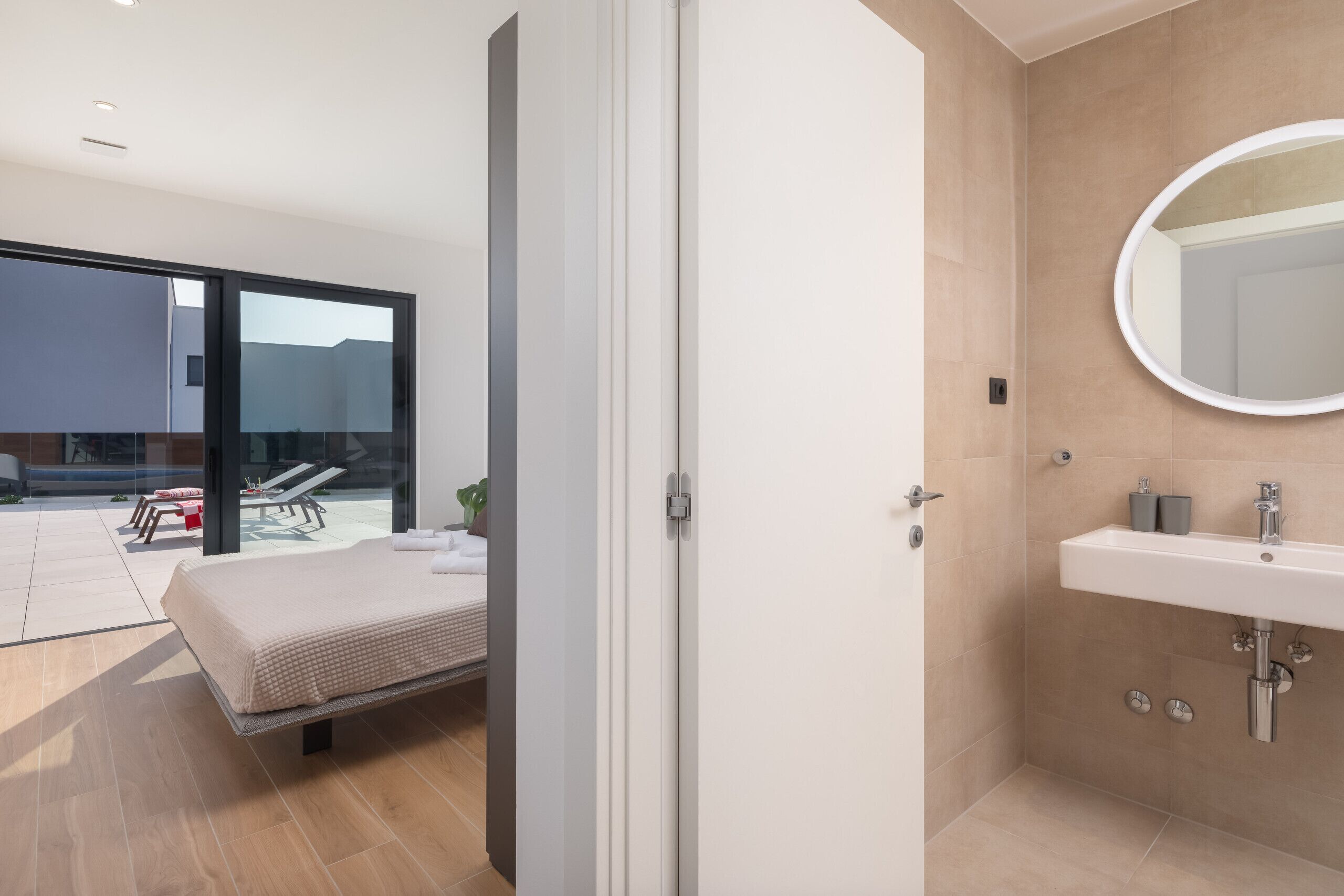 Une salle de bain moderne avec un grand miroir, un lavabo et une douche.