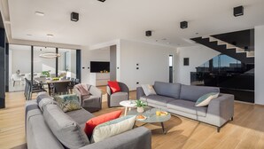 En moderne stue med en sofasæt, et spiseområde og en trappe.