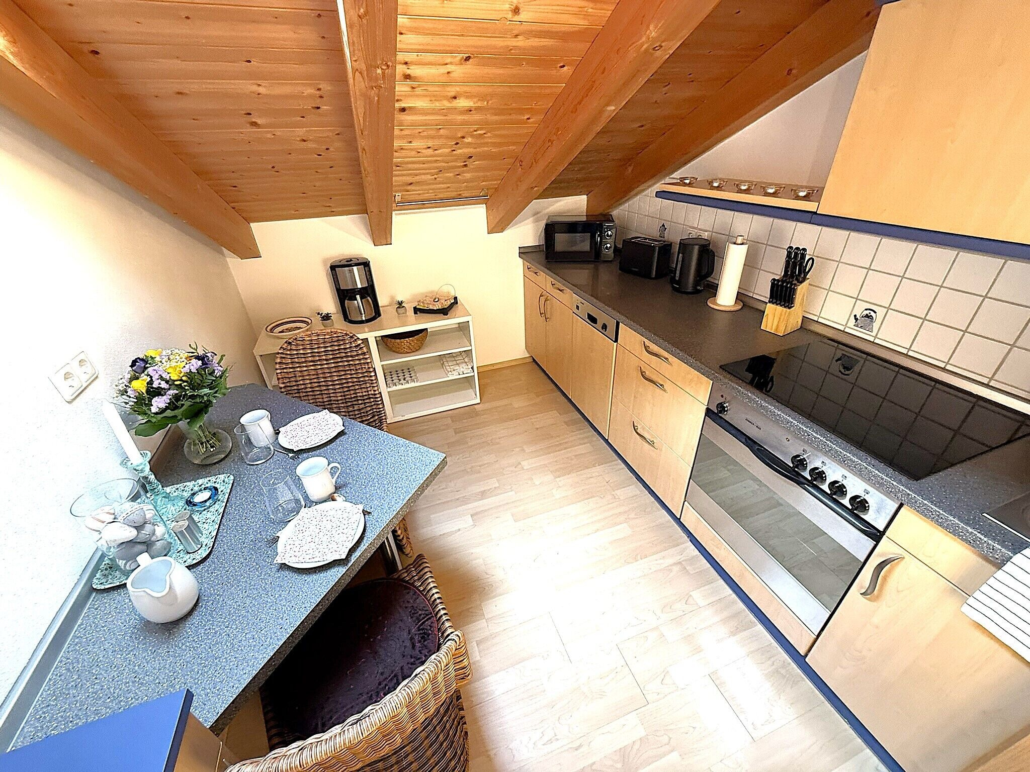 A compact kitchen with wooden cabinets, a microwave, a stove, and a sink.