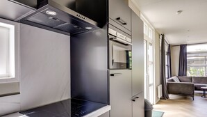 A modern kitchen with a built-in stove, oven, and microwave. There is a dining area with a table and chairs.