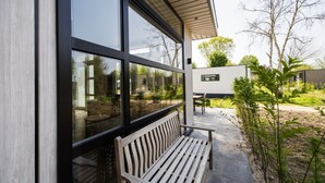 A modern building with large windows, a bench outside, and a signboard.