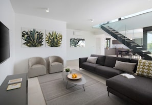 A modern living room with a sofa, armchairs, a coffee table, and artwork on the walls. - Vivi Rent Fažana - Villa Fasana Penthouse 5 (Fažana)