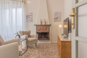 Una sala de estar con chimenea, un sofá, una mesa de centro y un aparador de madera.