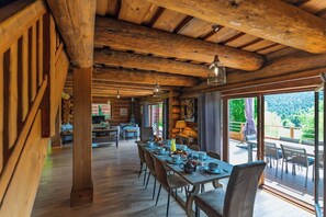 A wooden interior with a dining area, kitchen, and large windows. - ✨ Chalet Harmony – 9 Guests – Hot Tub – Close to Gérardmer (Liézey)