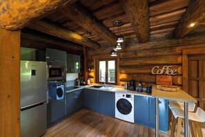 A modern kitchen with stainless steel appliances, a built-in washing machine, and a wooden ceiling. - ✨ Chalet Harmony – 9 Guests – Hot Tub – Close to Gérardmer (Liézey)