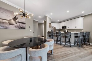 A modern kitchen with white cabinets, a black island, and bar stools. - Bristol Bay 34 - 3 Bdrm waterfront condo (Lake Ozark)