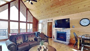 A cozy living room with a fireplace, a large TV, and a comfortable sofa. - Smoky Mountain View (Sevierville)