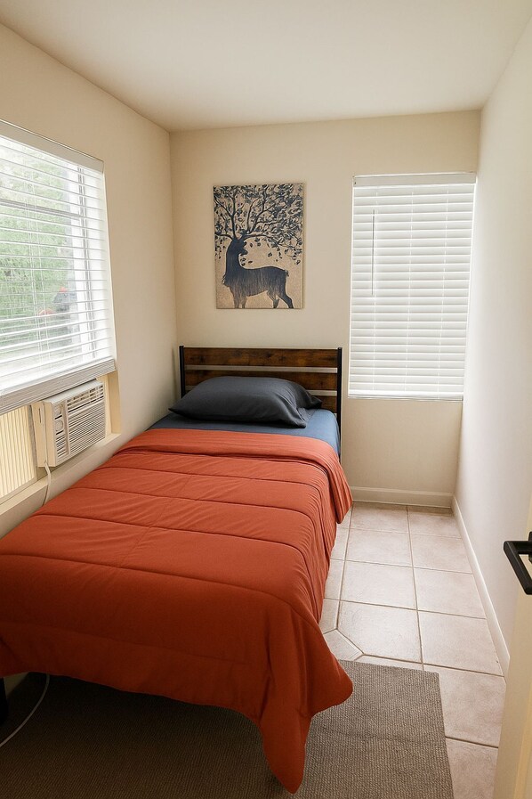A bedroom with a bed, a radiator, a window with blinds, and a wall-mounted artwork. - Cabana (Miami)