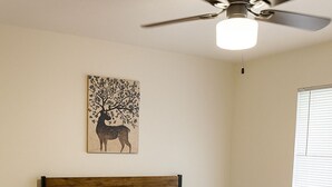 A bedroom with a bed, a ceiling fan, a window with blinds, and a wall-mounted artwork. - Cabana (Miami)