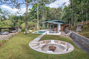 A modern house with a pool, outdoor seating, and a fire pit. - Peaceful Jungle Bungalow near La Fortuna / Nature, Pool & Relaxation / Orchidea (San Ramón de Ciudad Quesada)