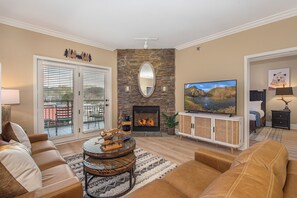 Ein Wohnzimmer mit Kamin, Fernseher und einer Couch.