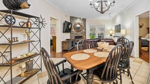 Uma área de refeições com uma mesa de madeira, cadeiras e um candelabro.