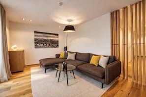 Ein modernes Wohnzimmer mit einer Eckcouch, einem Couchtisch und einer Pendelleuchte.