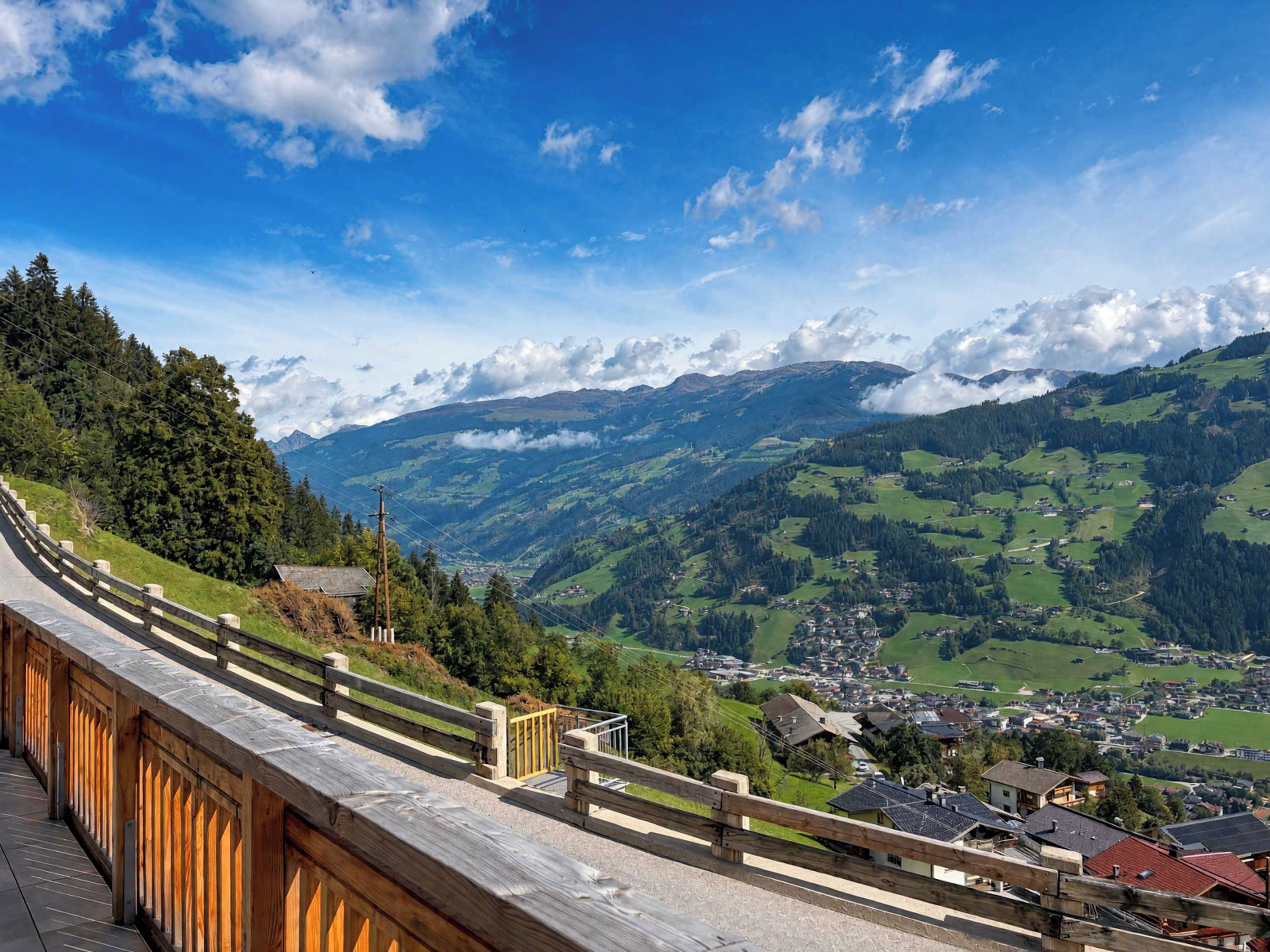 A scenic mountain view with a wooden walkway overlooking a valley.