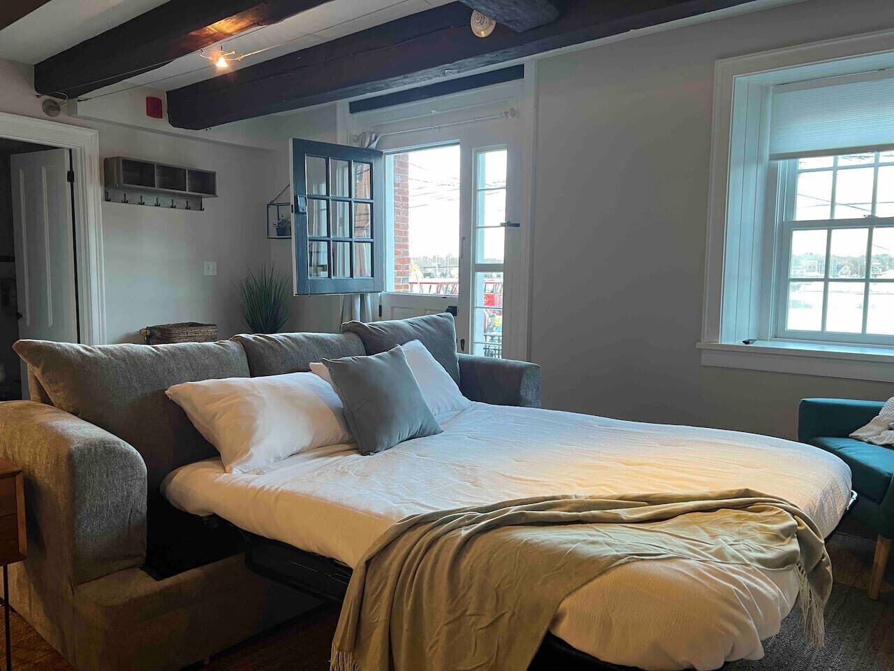 Une chambre à coucher avec un lit, une chaise, une fenêtre et une porte.