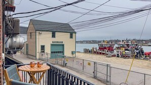 Un edificio con la leyenda 'Moran Towing', con vista al paseo marítimo y barcos.