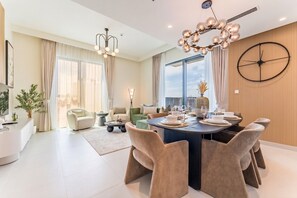 Ein modernes Wohnzimmer mit Essbereich, großen Fenstern und einer dekorativen Wanduhr.