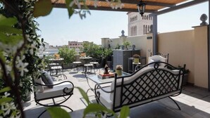 An outdoor patio with seating, a table, and potted plants. - Toscana 4 - FromHometoRome (Roma)