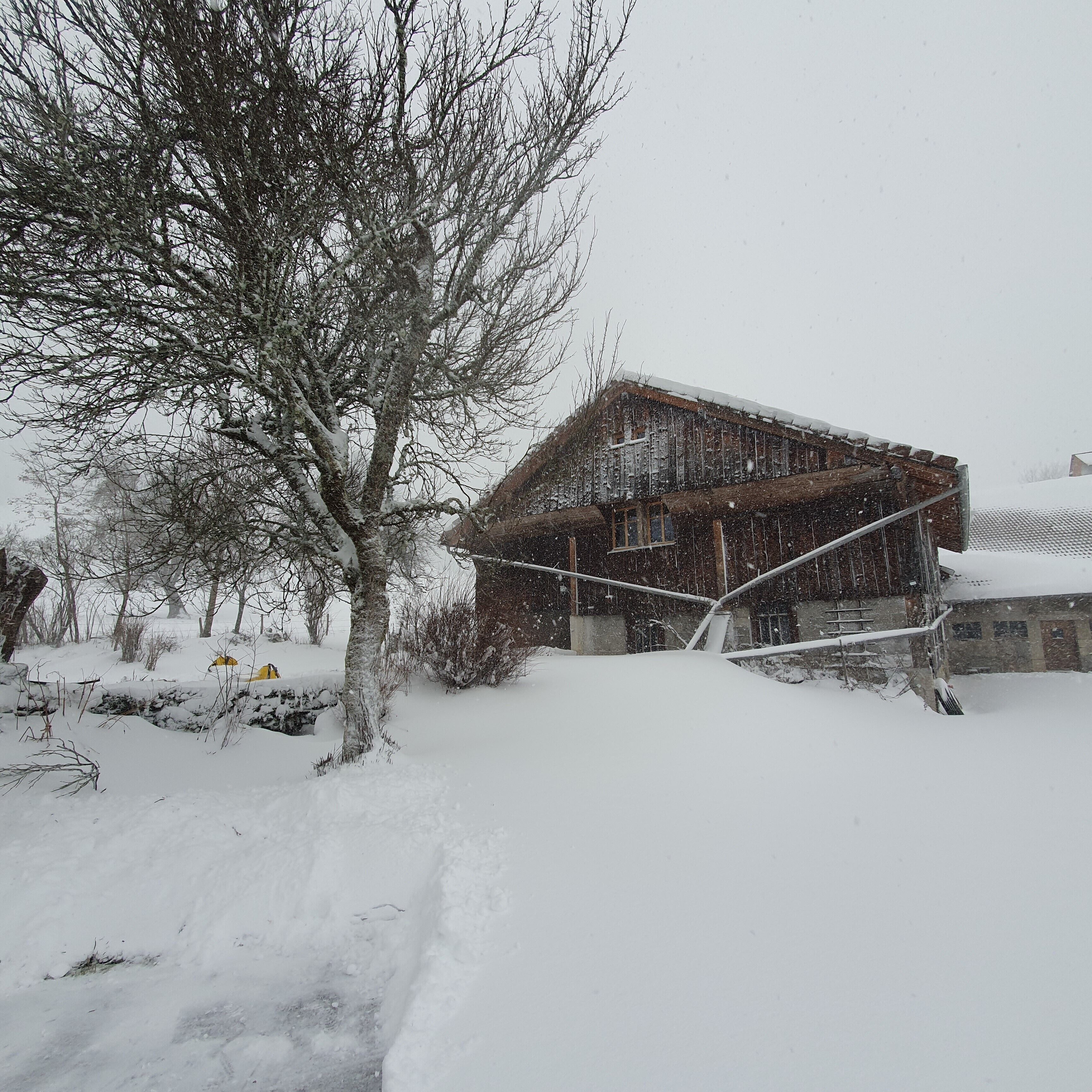 A snow-covered building with a metal roof and a wooden structure.