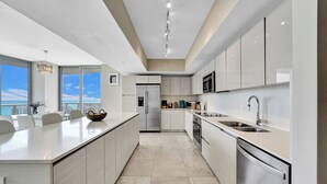 A modern kitchen with a central island, stainless steel appliances, and a view of the ocean. - Spacious 3-bedroom apartment Ocean View in lovely Hallandale Beach (Hallandale Beach)