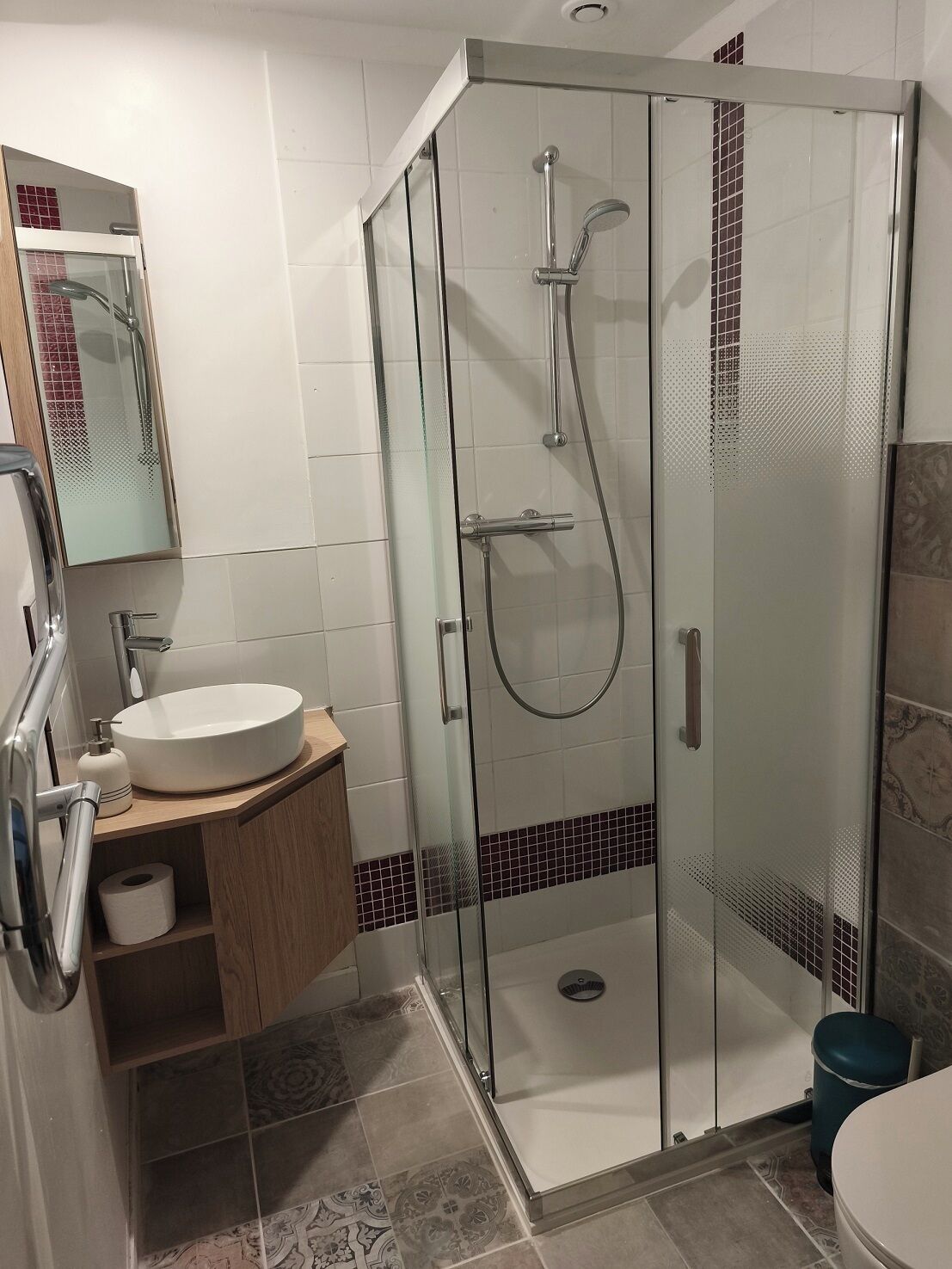 Une salle de bain moderne avec une douche à parois de verre, un lavabo avec un miroir et des toilettes.