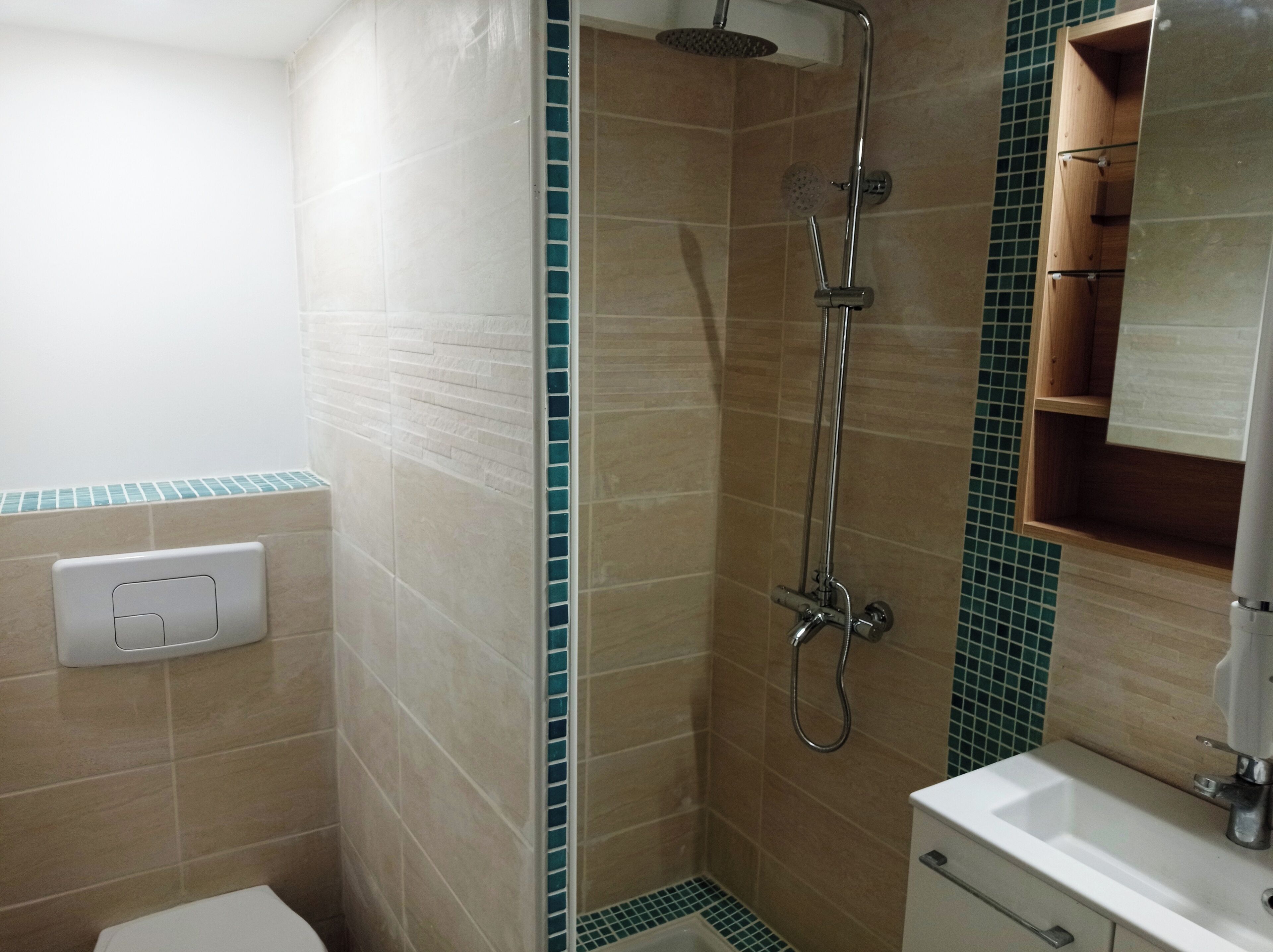 Ein Badezimmer mit Dusche, Toilette, Waschbecken und Spiegel.