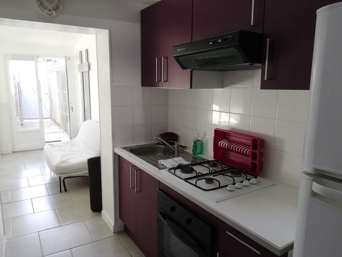 Une cuisine équipée d’une cuisinière à gaz, d’un évier et de placards.