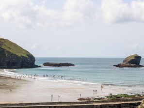 A beach with rocky outcrops, clear blue water, and a sandy shore. - Warleggan (Redruth)