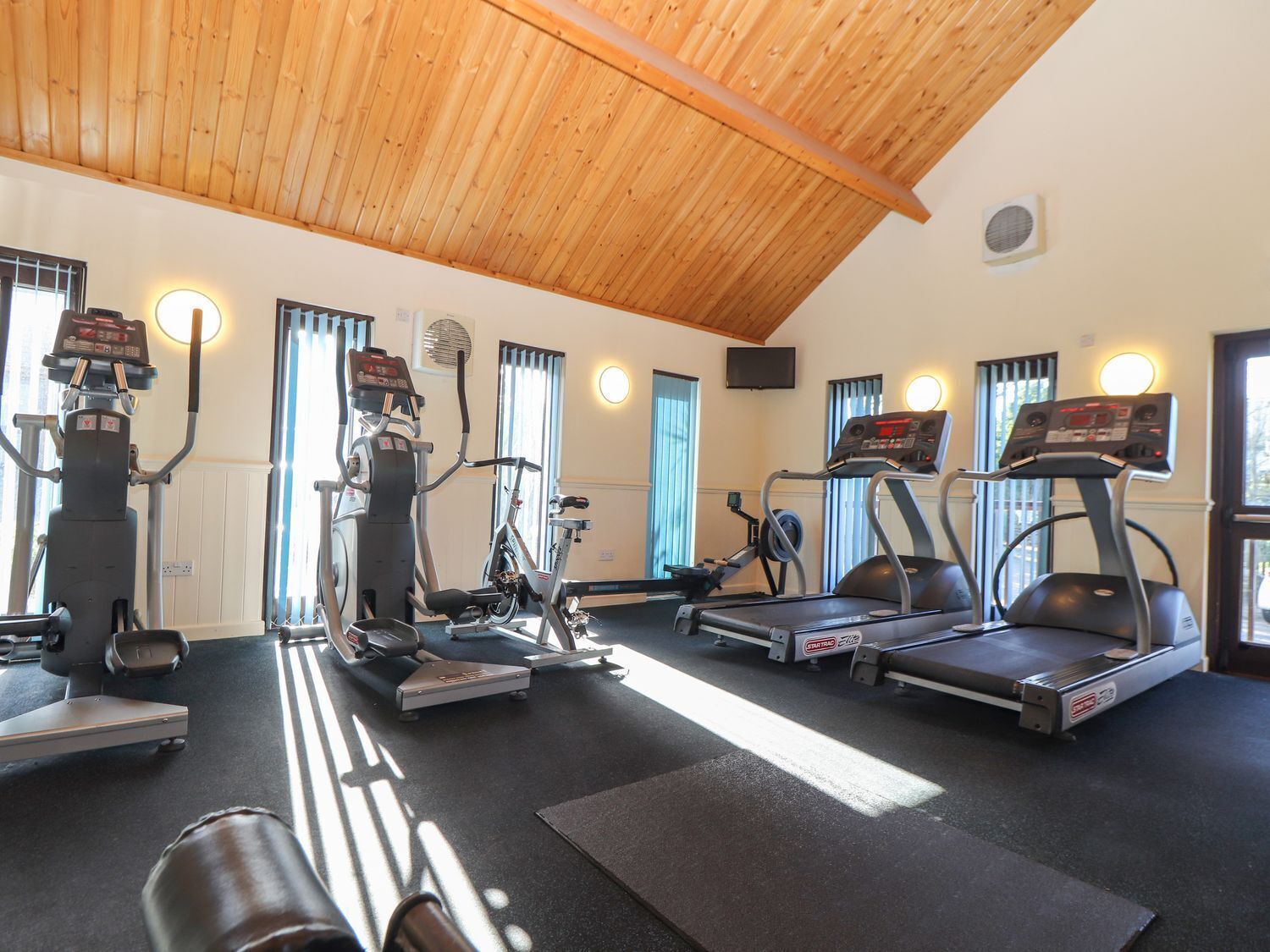 A gym with treadmills, elliptical machines, and stationary bikes.
