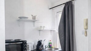 A compact kitchenette with a microwave, toaster, and small refrigerator. - Hammersmith Stayz (London)