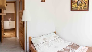 A bedroom with a bed, a bedside lamp, a radiator, a door, and a painting on the wall. - Double room, sauna, Masuria (Ruciane Nida)