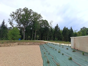 A rooftop garden with a gravel area and a green mat with plants. - Périgord. gite sleeps 8 or 12, 4*, private heated pool, large open spaces. (Lempzours)