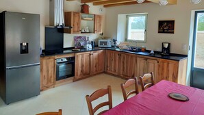 A kitchen with wooden cabinets, a stainless steel refrigerator, a microwave, and a sink. - Périgord. gite sleeps 8 or 12, 4*, private heated pool, large open spaces. (Lempzours)