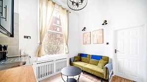 Eine moderne Küche mit Spüle, Esstisch und einem Fenster mit Vorhängen.