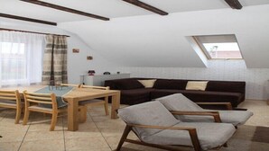 A loft-style room with a dining area, a sofa, and a window with a view. - Holiday apartment for 4 people, Rowy (Rowy)