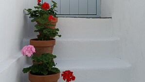 Una escalera blanca con una puerta azul claro al final.