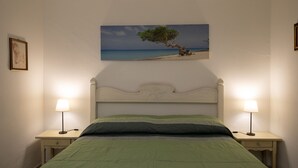 A bedroom with a bed, two bedside tables with lamps, a painting of a tree on the wall, and a headboard. - Alba Marina by Wonderful Italy (Olbia)