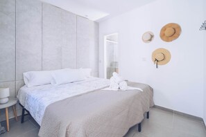 Ein modernes Schlafzimmer mit einem Bett, einem Nachttisch und einem an der Wand befestigten Haken für Hüte.