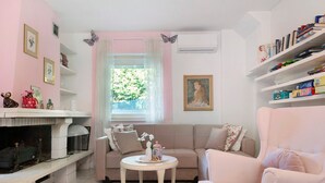 Un salon avec une cheminée, un canapé, une table basse et une bibliothèque.