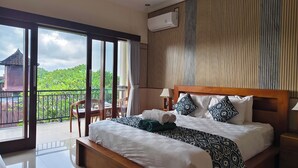 A hotel room with a large bed, a balcony with a view, and an air conditioning unit. - Danu House Ubud (Ubud)